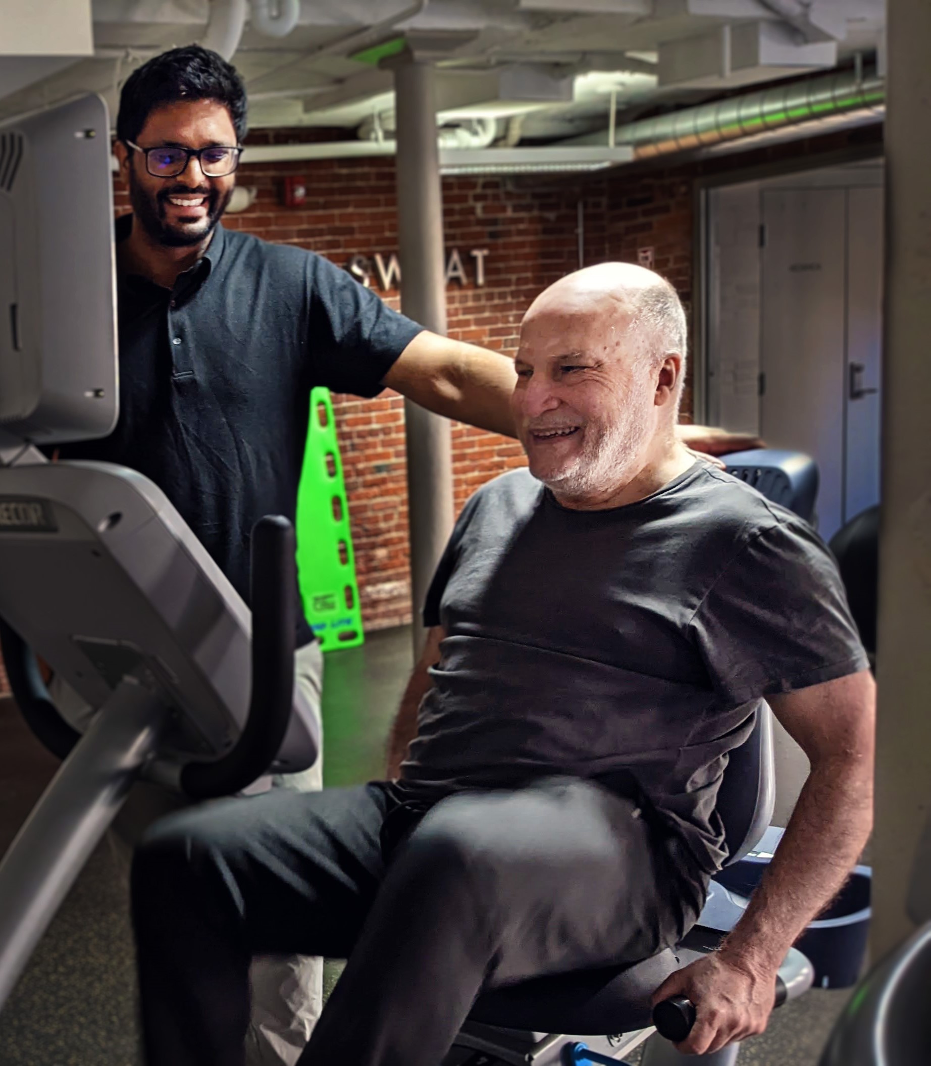 Personal training session with AMIM trainer and senior using a recumbent bike